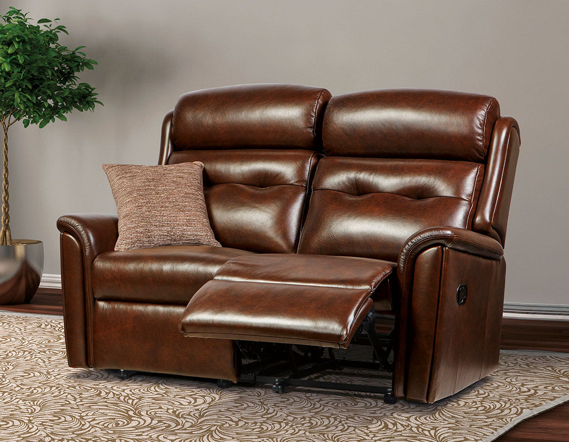 Sherborne Roma Brown leather recliner sofa in a living room setting with a plant and rug.