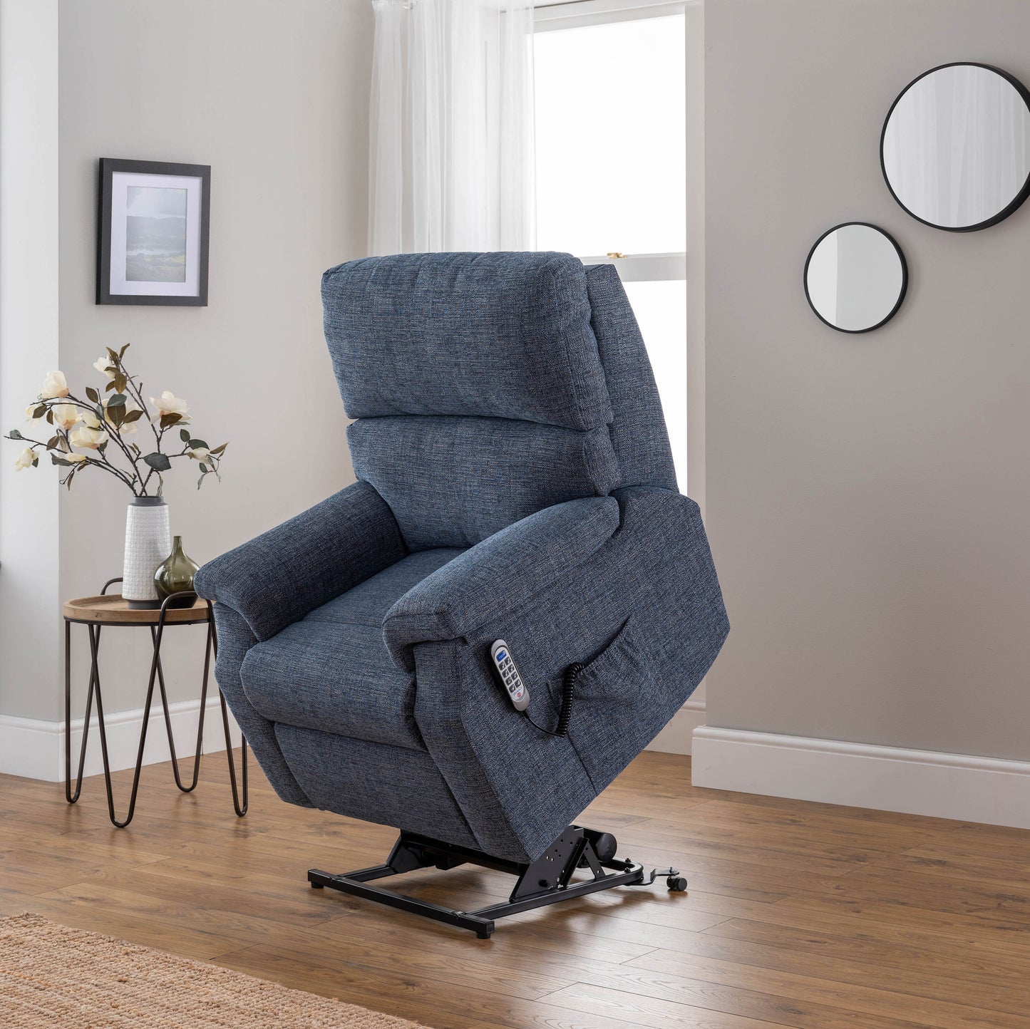 Blue celebrity newstead lift chair in a living room setting with a side table and decor items.