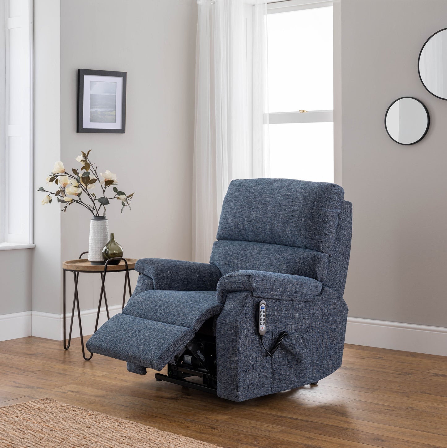 Blue celebrity newstead recliner chair in a living room setting with a side table and decor.