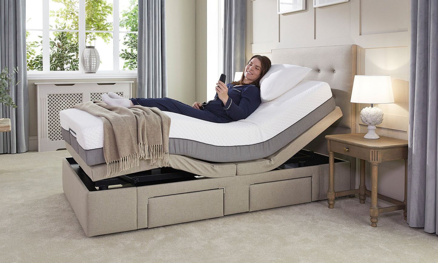 Woman lying on an adjustable bed in a bedroom setting