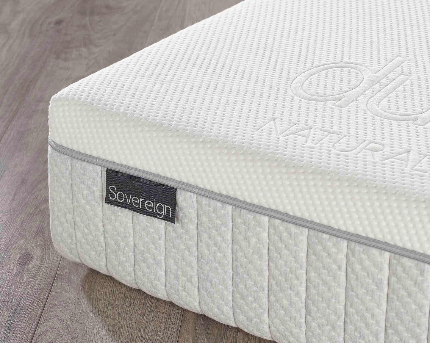 White mattress with 'Sovereign' branding on a wooden floor