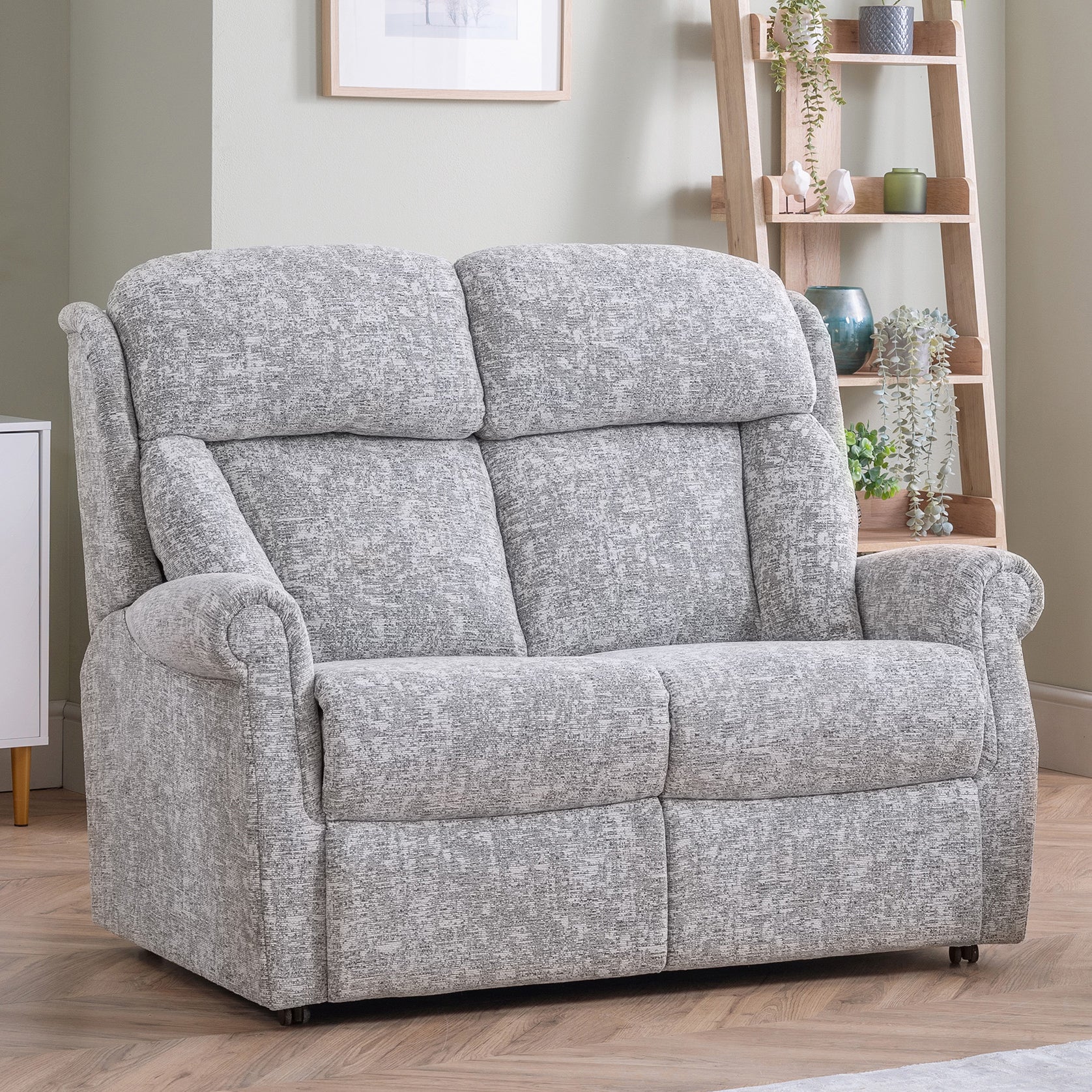 Gray upholstered celebrity ashfield sofa in a room with a bookshelf and framed picture.