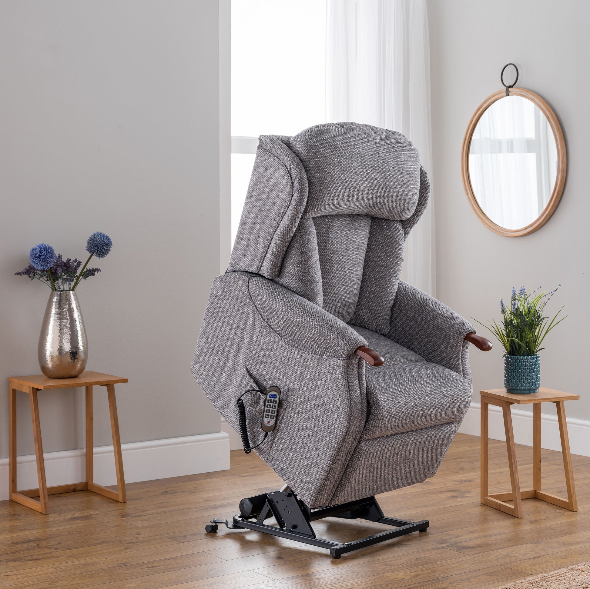 Gray recliner chair in a room with wooden floors and side tables.