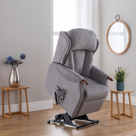 Gray recliner chair in a room with wooden floors and side tables.
