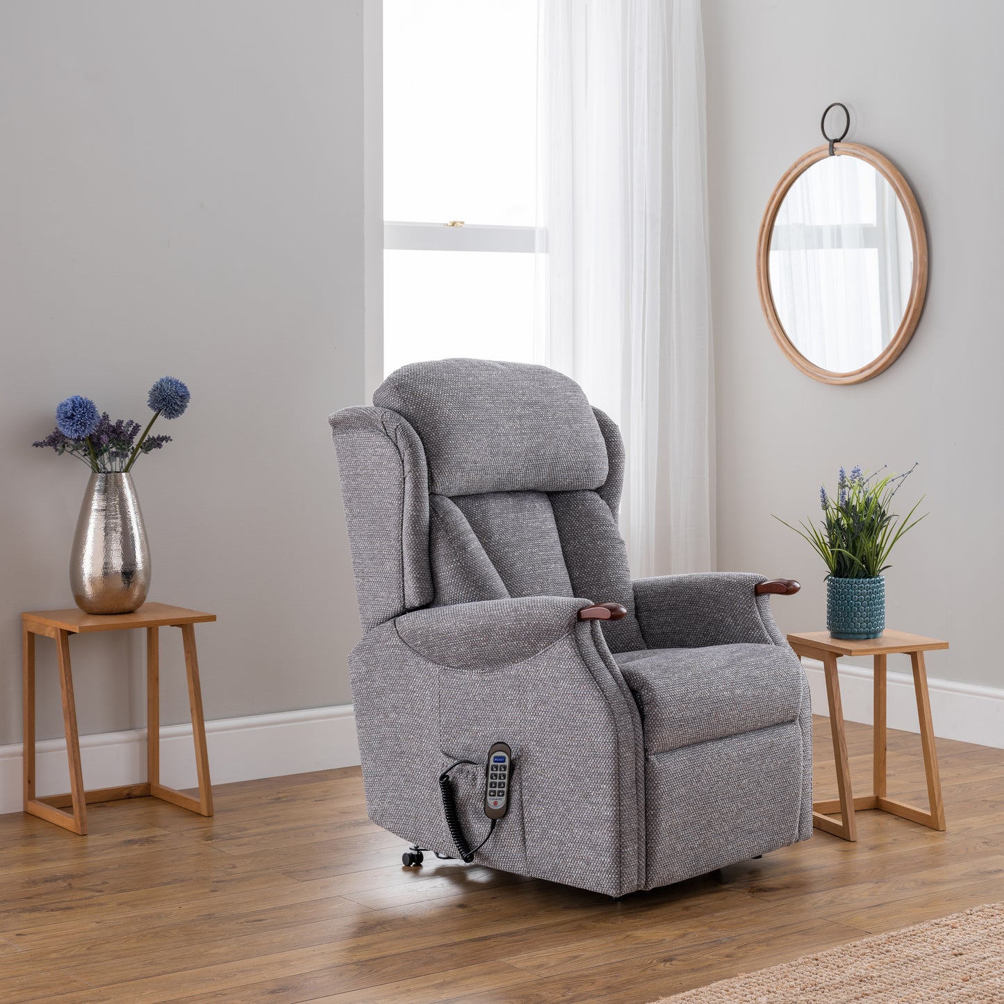 Gray recliner chair in a room with wooden floors and light gray walls.