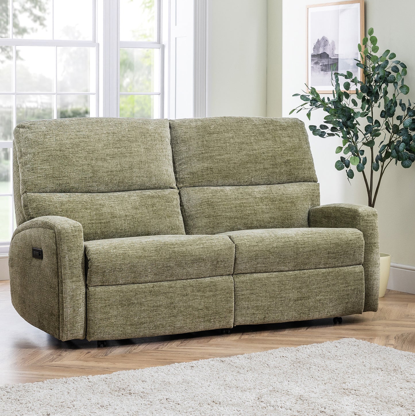 Green Celebrity Southwell sofa in a living room with a plant and window in the background