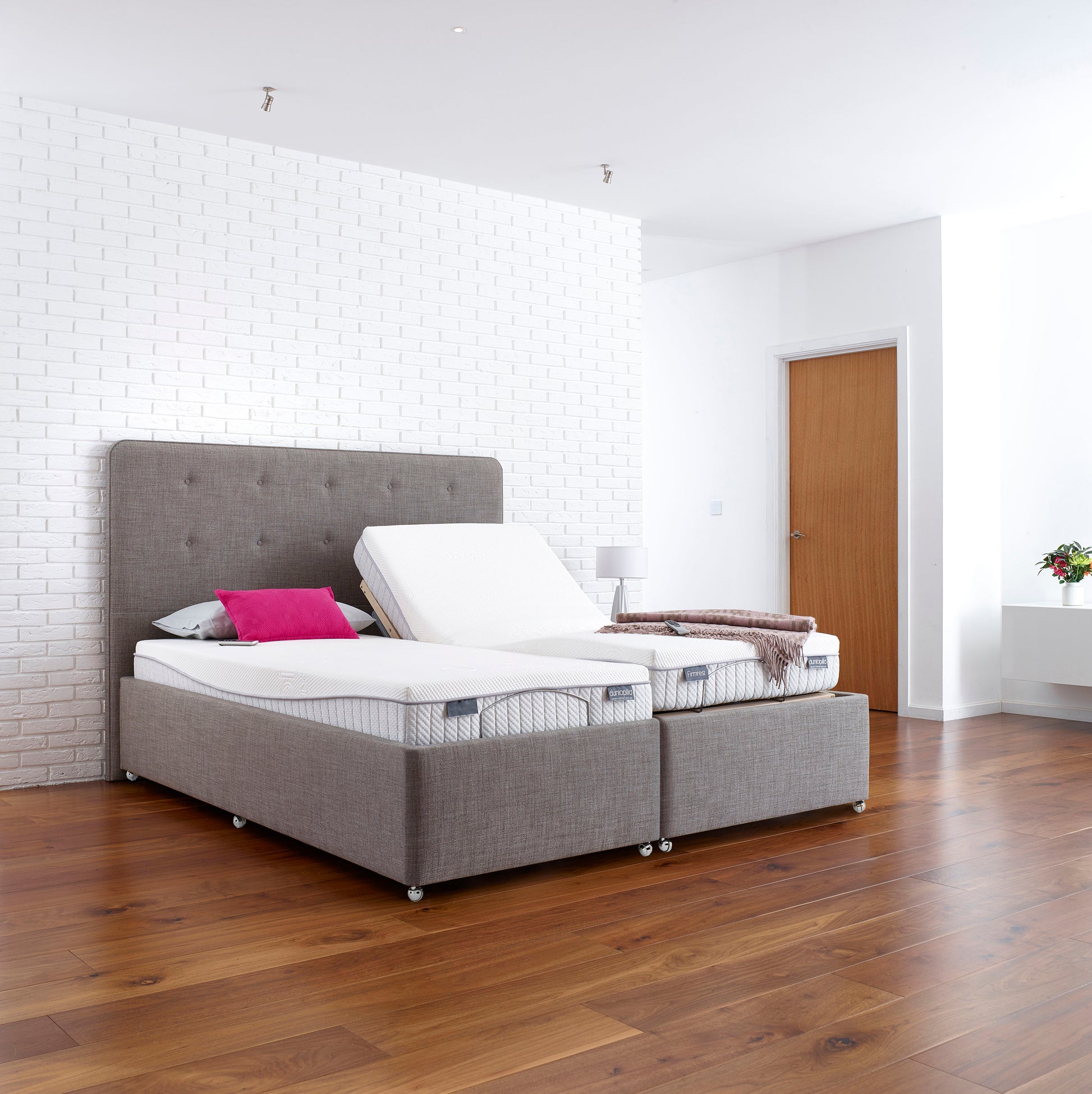 Gray adjustable bed with white mattress in a modern bedroom setting.