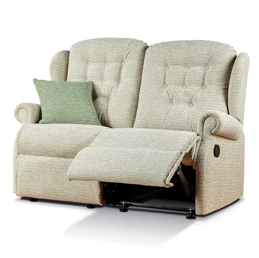 Beige recliner sofa with a green pillow on a white background