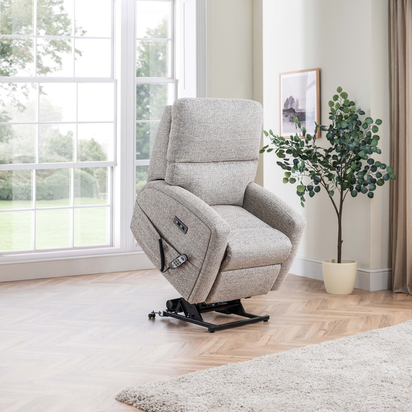 Gray Celebrity Southwell recliner chair in a room with a large window and a plant.