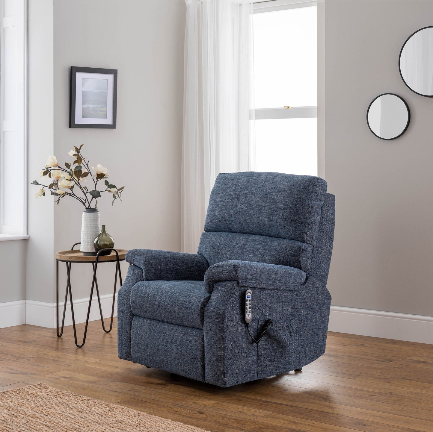 Blue celebrity newstead recliner chair in a living room setting with a side table and decor.
