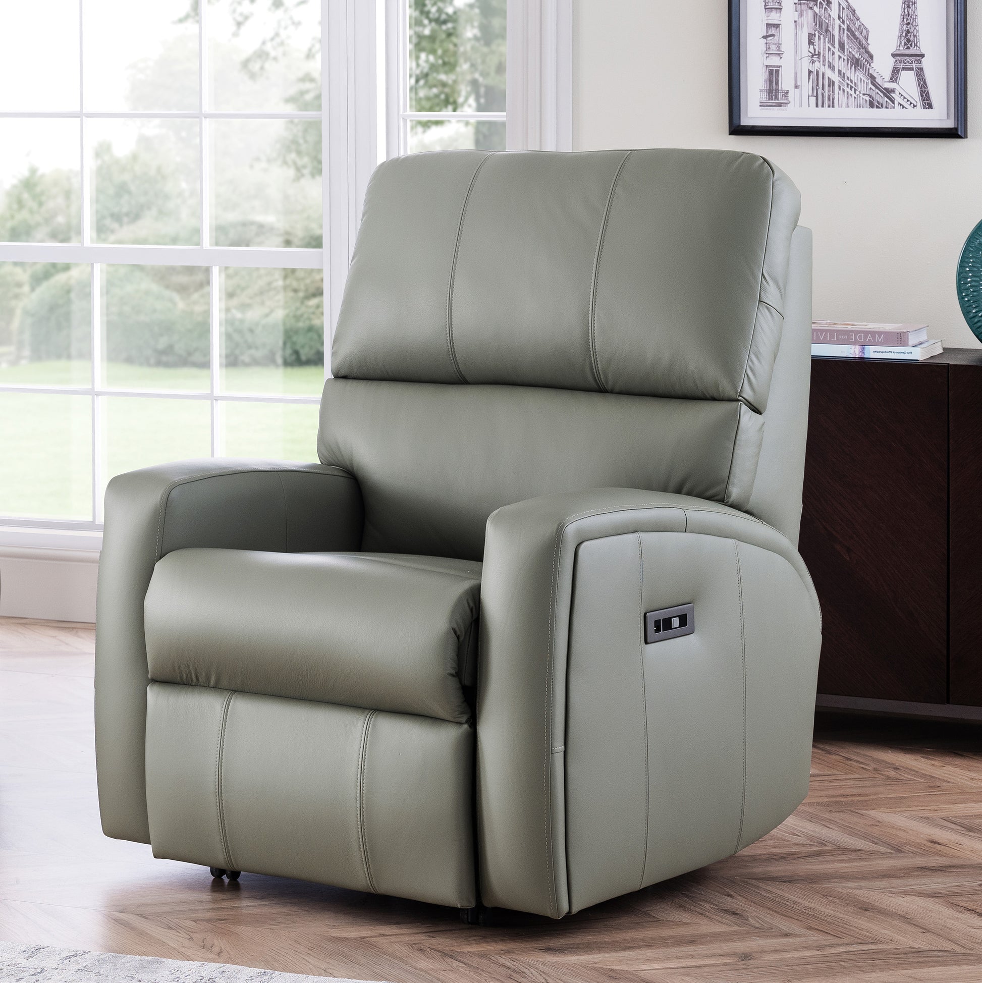 Gray celebrity southwell recliner chair in a room with large windows and a framed picture on the wall.