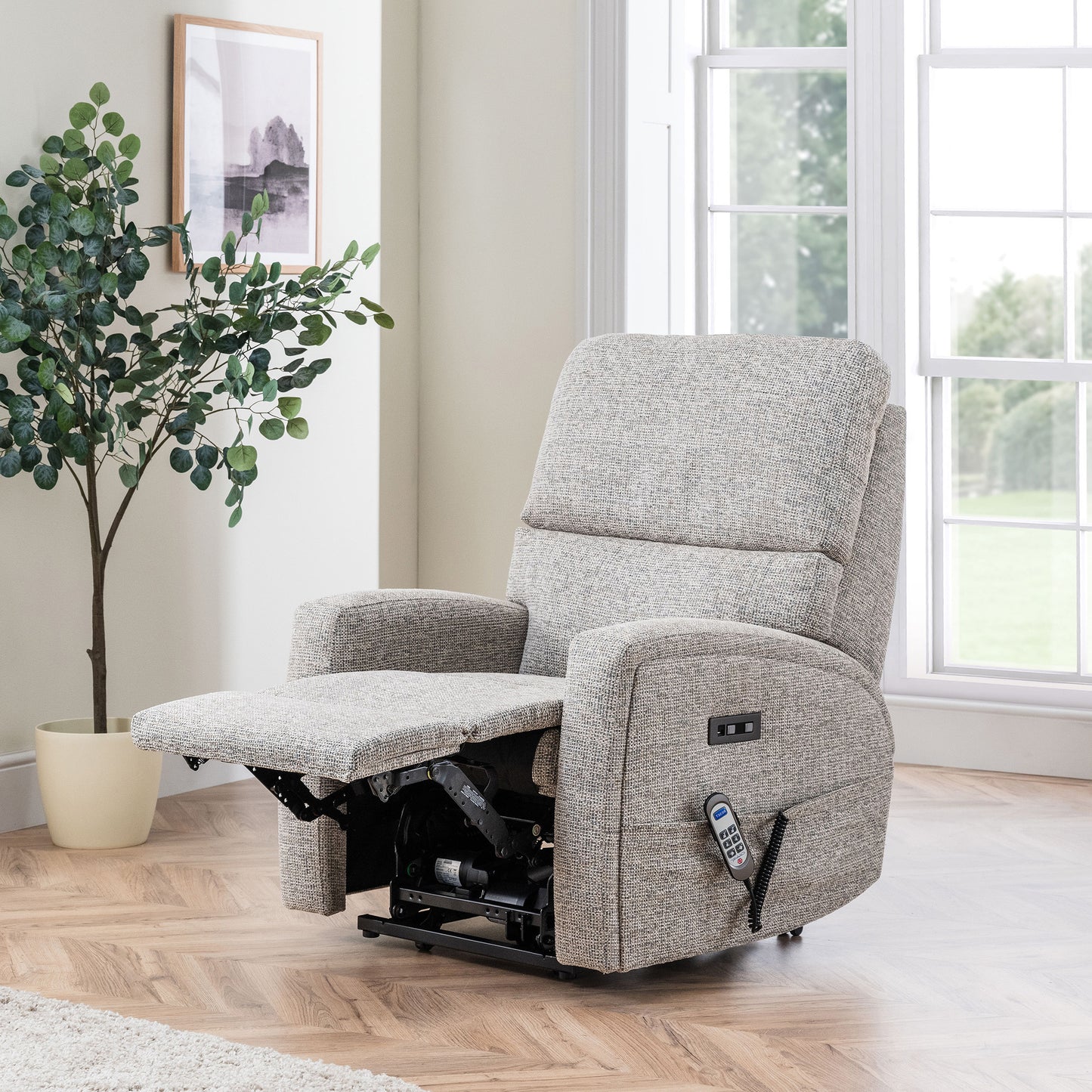 Gray Celebrity Southwell recliner chair in a living room with a plant and window in the background