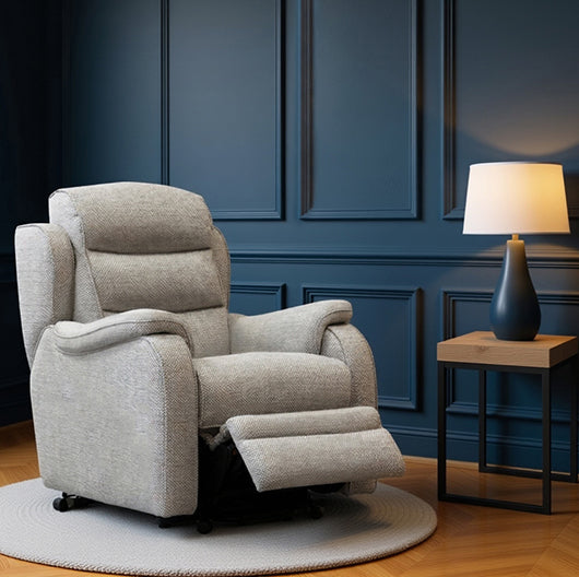 Gray recliner chair in a room with blue paneled walls and a side table with a lamp.