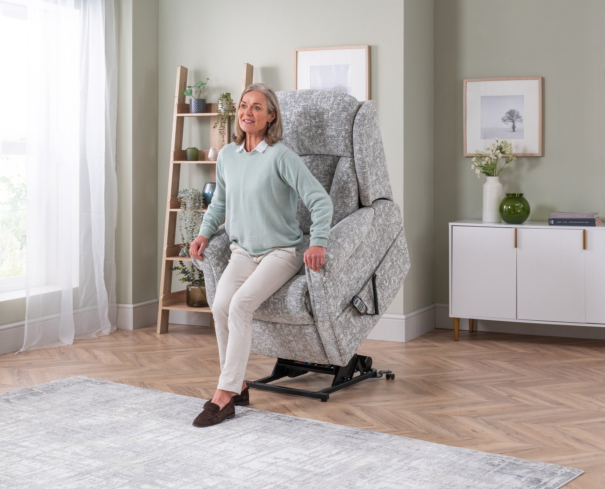 Woman using a gray recliner chair in a home setting with decor elements.